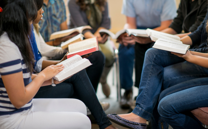 Groupe de personnes qui lisent un livre - copyright canva